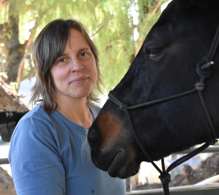 Amelia Nalli MMCP A woman smiling with a horse.