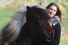 A woman smiling with a horse.