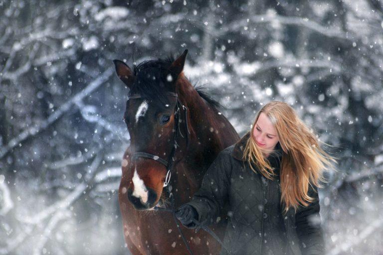 woman and horse in winter snow