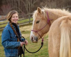 Melissa Isgett MMCP MMES A woman smiling with a horse.