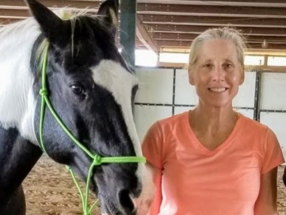 Photograph of Lori Thompson holding a horse