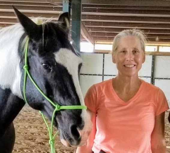Photograph of Lori Thompson holding a horse