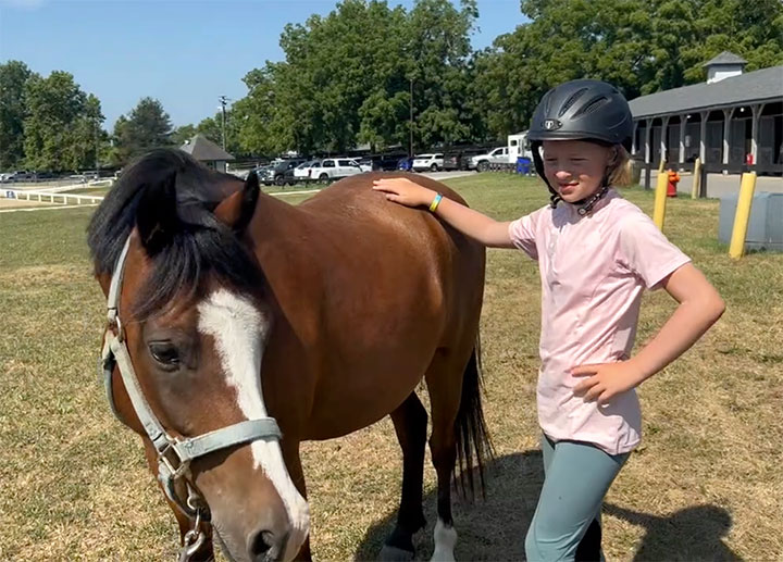 Photo of girl touching pony using Bladder Meridian technique.