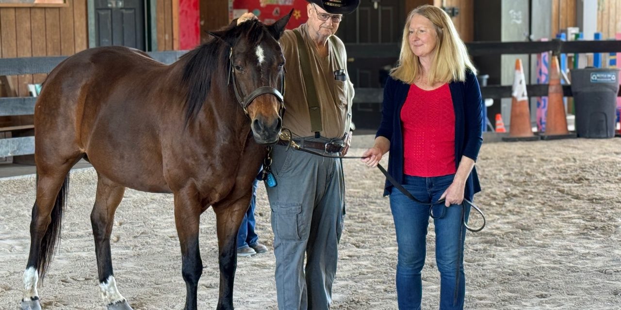 VeteransBlogPost-Vet Danny Photo of man resting his hand on horse's poll and woman holding lead rope.