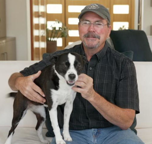 man holding a black and white dog