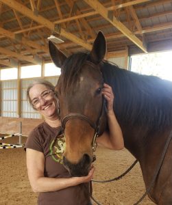 A woman smiling with her horse.