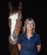 A woman standing with her horse.