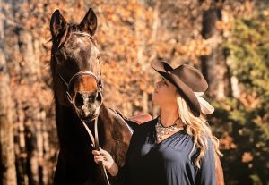 A woman smiling at her horse.