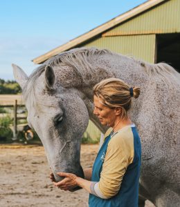 A woman standing with a horse.