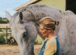 A woman standing with a horse.