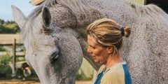 A woman standing with a horse.