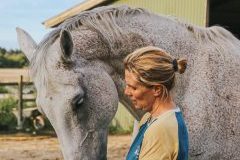 A woman standing with a horse.