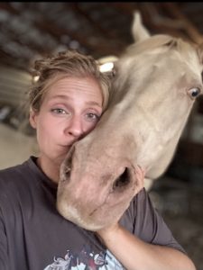 A woman standing with a horse.