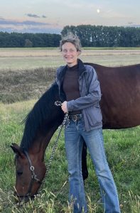 A woman standing with a horse.