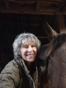 A woman smiling with her horse.