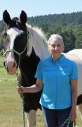 Lori Thompson MMCP A woman standing with her horse.