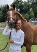 A woman smiling with a horse.