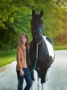 A woman, standing with her horse.