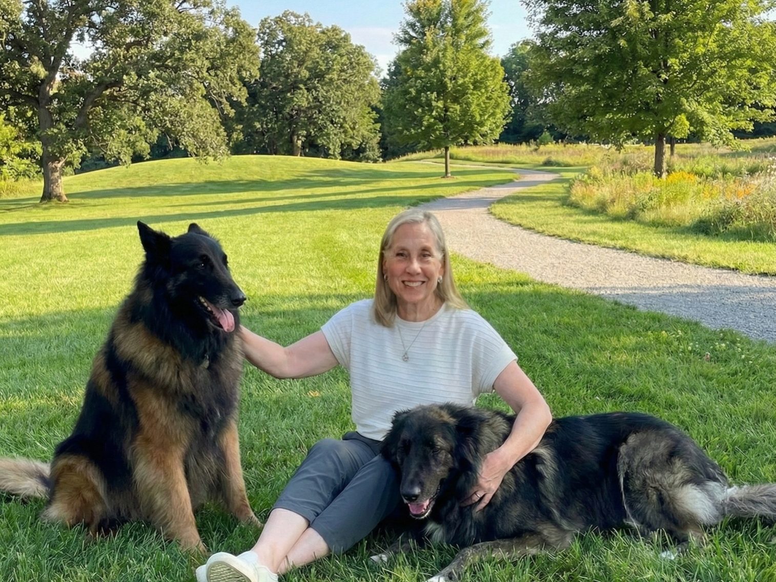 Woman holding two dogs in a park