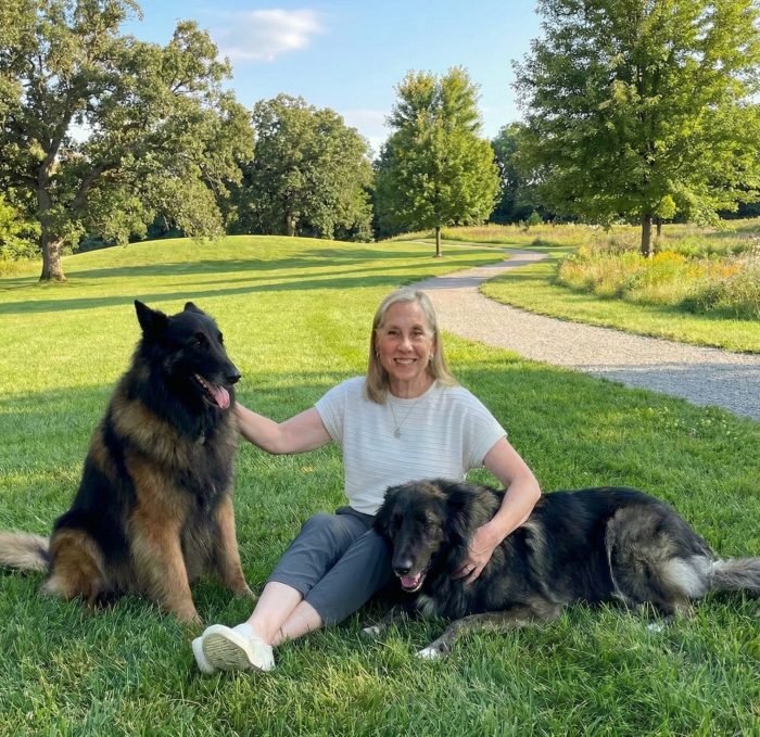 LoriThompsonDogs Woman holding two dogs in a park