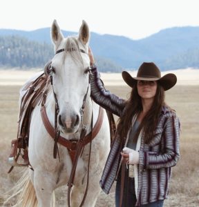A Woman standing with her horse.