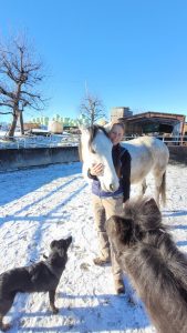 A woman with a horse in the snow.