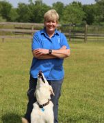 A woman standing with her dog.