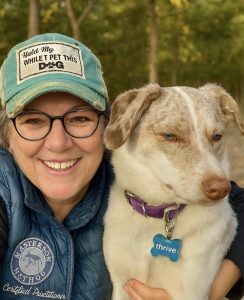 A woman smiling with her dog.