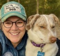 A woman smiling with her dog.