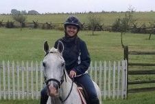 A woman riding a white horse.
