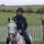 A woman riding a white horse.