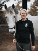 A woman smiling with her horse.