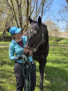 A woman standing with her horse.