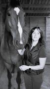 A woman standing with her horse.