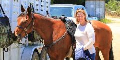 A woman standing with a horse.