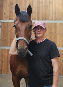 Marcin standing with a horse.