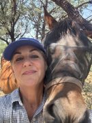 A woman smiling with her horse.