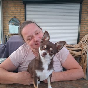A woman smiling with her dog.
