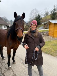 A woman standing with her horse.