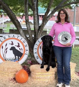 A woman standing with her dog.