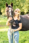 A woman standing with a horse.