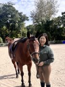 A woman standing with her horse.
